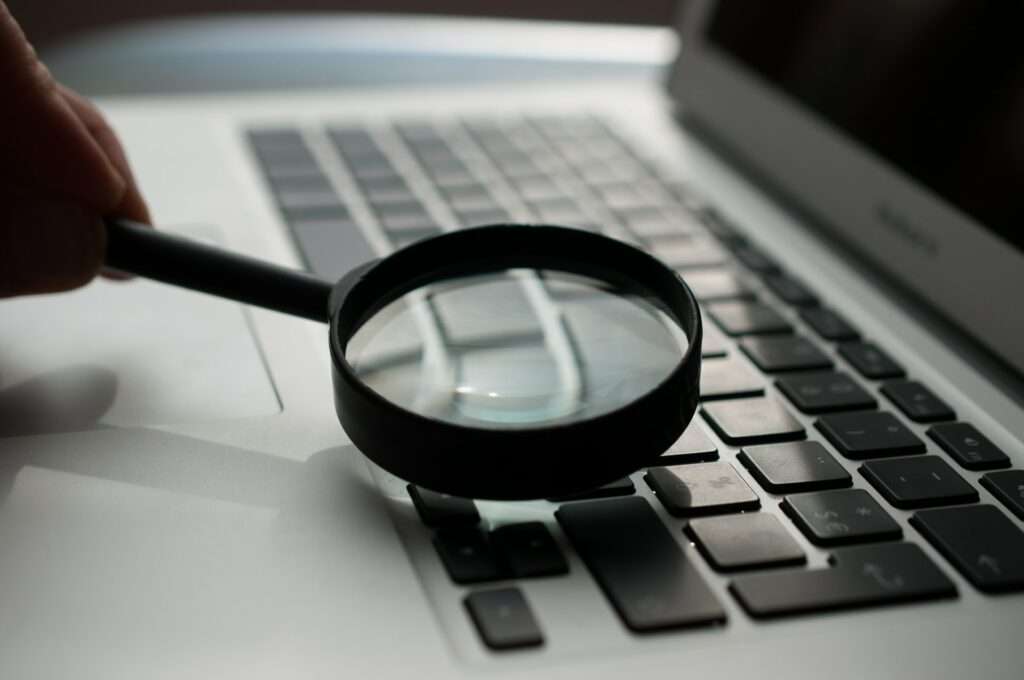 magnifying glass near gray laptop